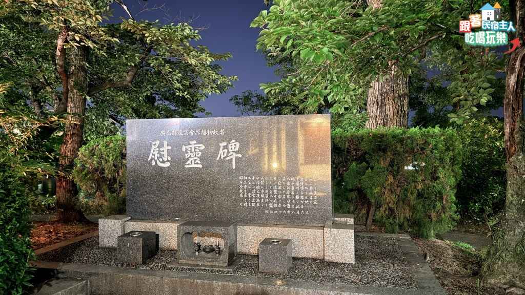 廣島縣農業會原爆物故者慰靈碑,黑色大型石碑立於公園樹叢間,碑前設有供台