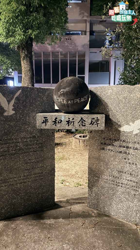 平和祈念碑全景,石造拱門中央立有刻著PEOPLE AT PEACE與世界地圖的黑色石球