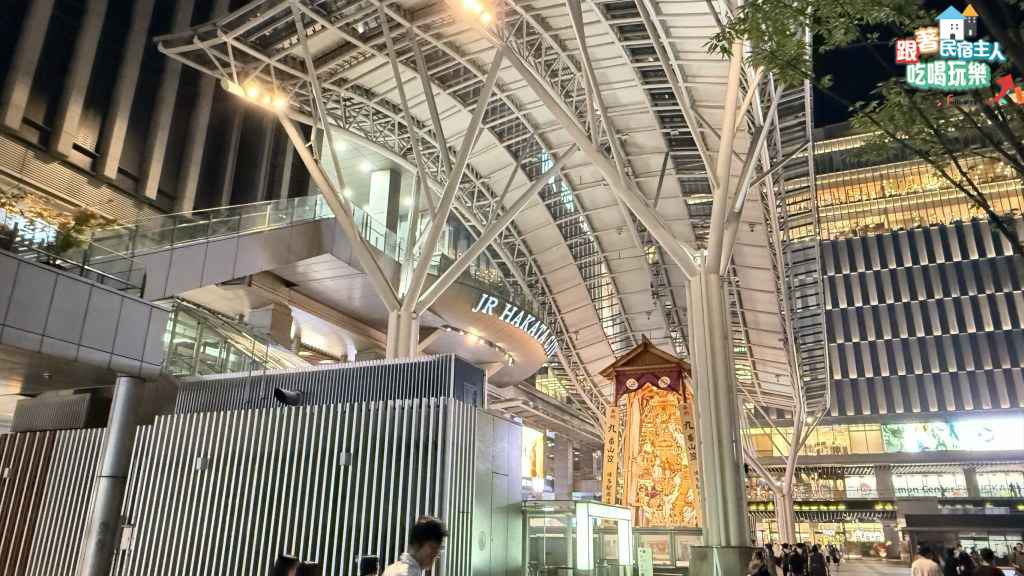 博多站前廣場夜景,計程車排隊候車區與FUN HAKATA彩色插畫看板同框