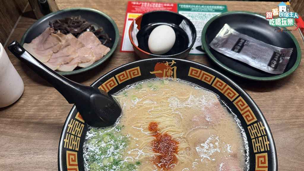 一蘭天然豚骨拉麵近拍,濃白湯頭中央放著赤紅色秘製醬汁,搭配細捲麵與叉燒