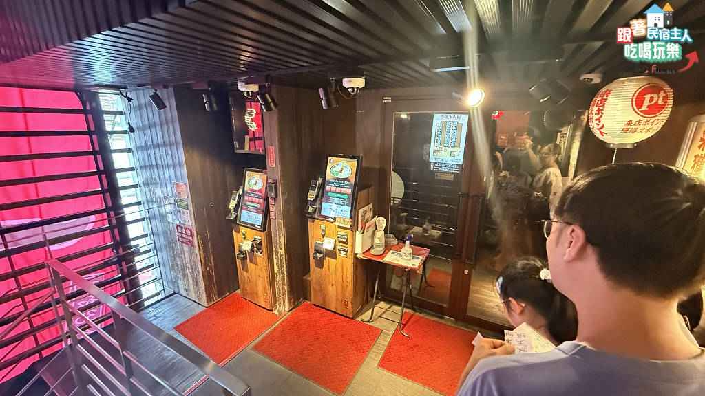 一蘭經典味集中單人隔間吧檯座,木質隔板一格一格排列,紅色圓凳整齊擺放