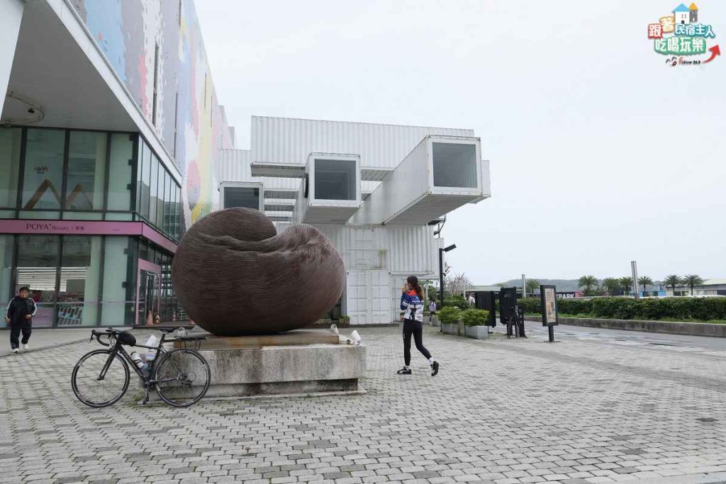 旅行者坐在光復糖廠外吃烤香腸與冰淇淋的補給休息畫面