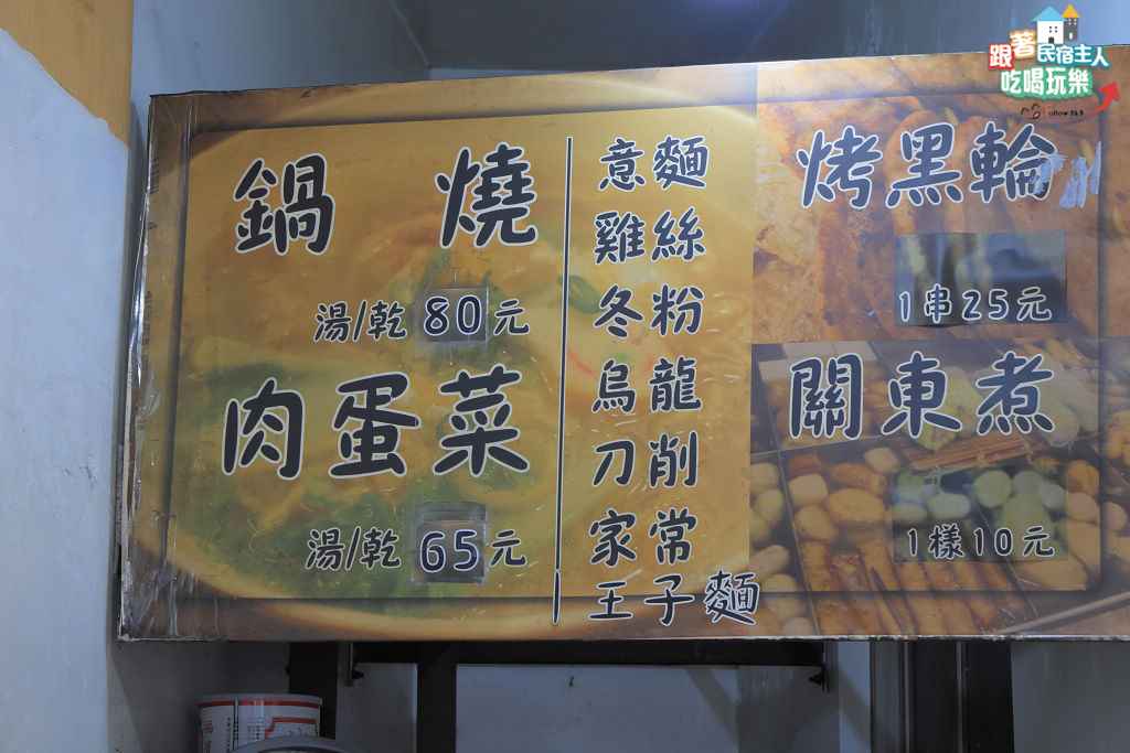 牆上手寫價目看板,清楚列出鍋燒麵、肉蛋菜麵與各項配料價格
