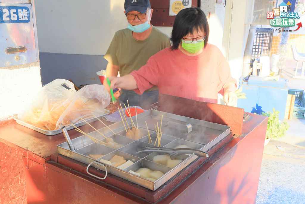 老闆娘拿著夾子在關東煮鍋旁準備撈料,老闆在一旁顧火