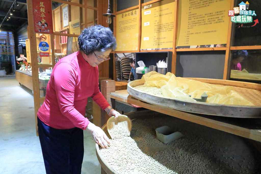 師傅彎腰俯身攪拌大缸中的醬油原料,每兩三天就要重複這個動作長達一年
