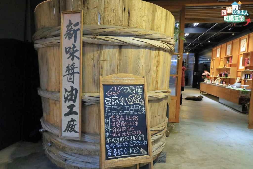 新味醬油展示門市入口,昏黃燈光映照老木牆,瀰漫著古早醬油廠的歲月感