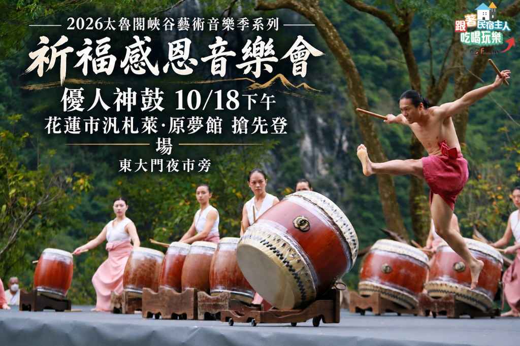優人神鼓鼓手身著白色上衣與粉色長裙,在花蓮山林背景前排開陣勢備演