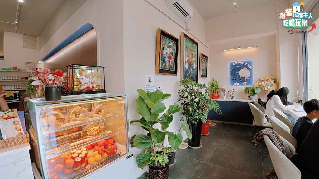咖兜入口甜點展示櫃與牆上色彩濃烈的油畫裝飾
